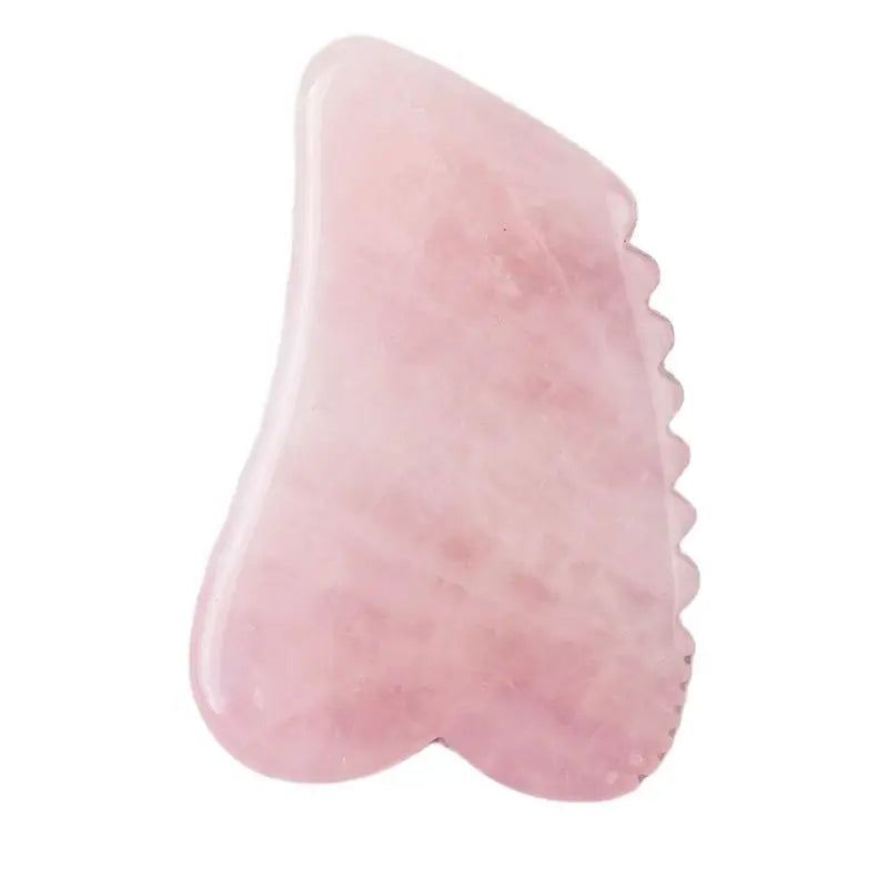 Pink gua sha tool on a white background